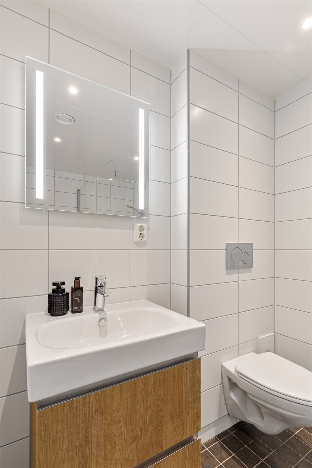 Badet fremstår som både funksjonelt og innbydende, med servant, klosett og dusj rett på gulv. Galleribilde