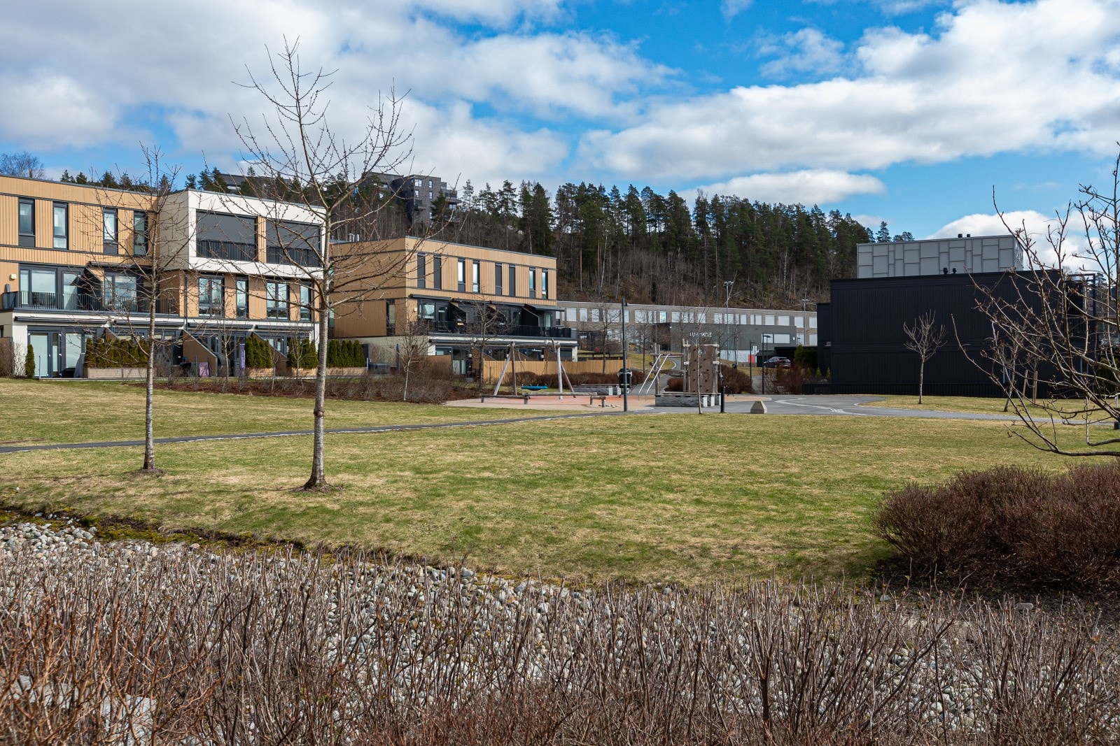 Tomtens fellesarealer er pent opparbeidet med plener, trær, diverse beplantning, sykkelstativ og internveier. Galleribilde