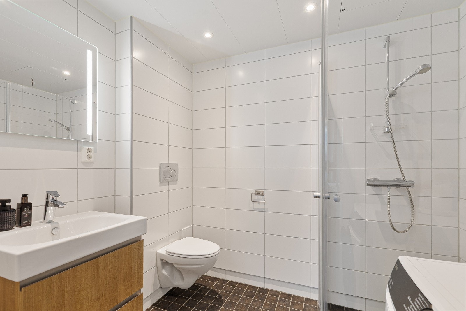 Flislagt og delikat baderom med vannbåren gulvvarme og downlights som gir en behagelig og moderne atmosfære. Galleribilde