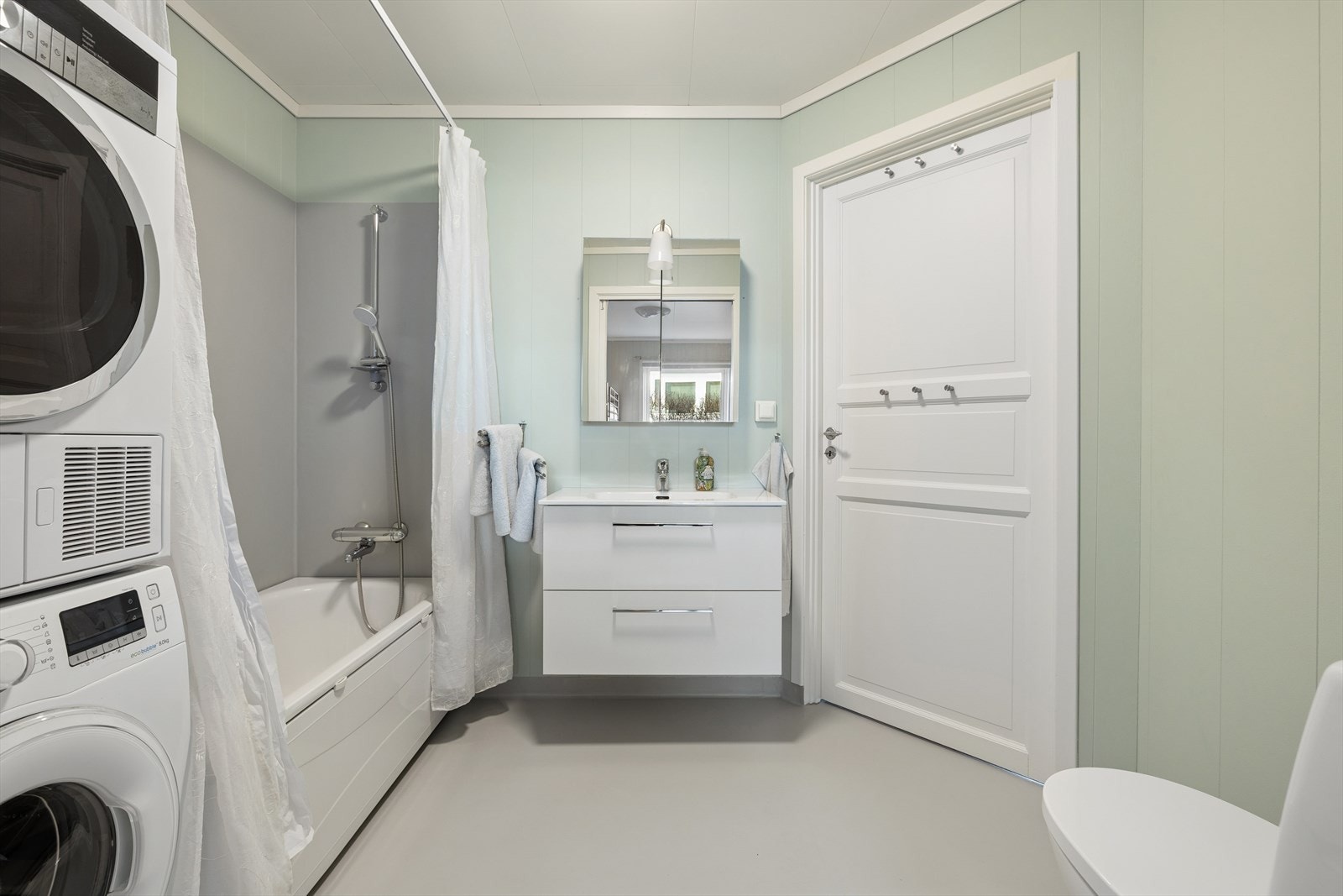 Badet er praktisk innredet med badekar, servantskap, toalett og opplegg for vaskemaskin og tørketrommel. Mekanisk avtrekk. Galleribilde