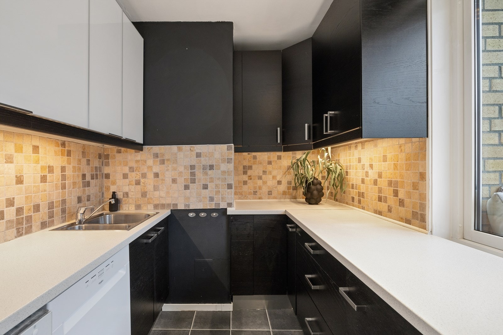 IKEA-kjøkkeninnredning med slette fronter og laminat benkeplate med en nedfelt oppvaskkum i rustfritt stål. Galleribilde