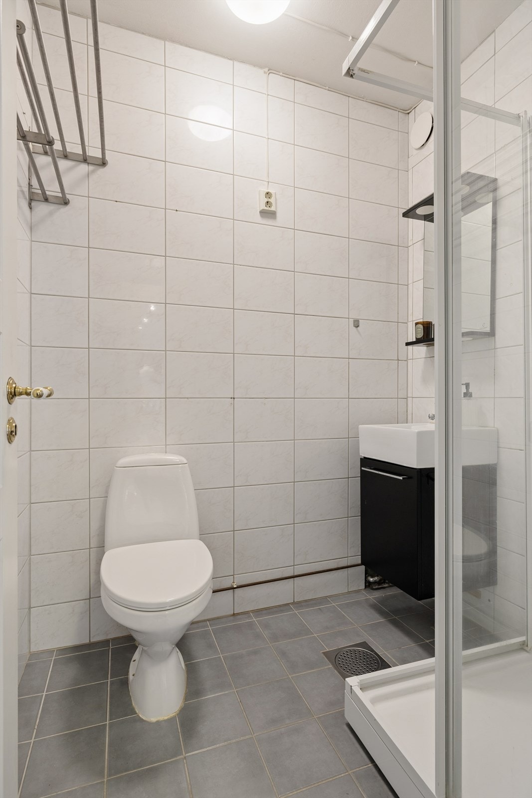 Badet er utstyrt med frittstående toalett, dusjkabinett og baderomsinnredning med heldekkende servant. Galleribilde