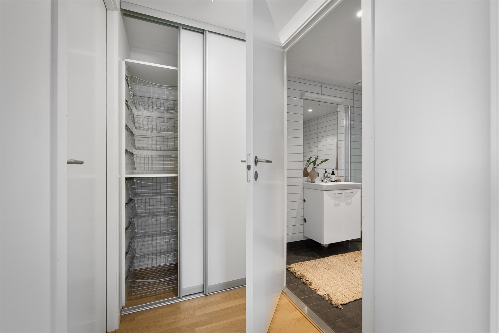 I gangen mellom stuen og baderommet er det en romslig, plassbygd skyvedørsgarderobe Galleribilde