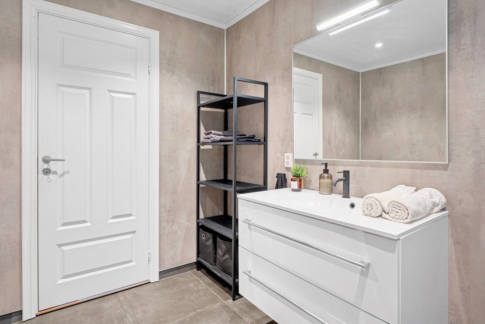 Badet i 1. etasje er fra 2020 og har flislagt gulv med varmekabel, baderomsplater på vegger og himlingen med malte plater. Galleribilde