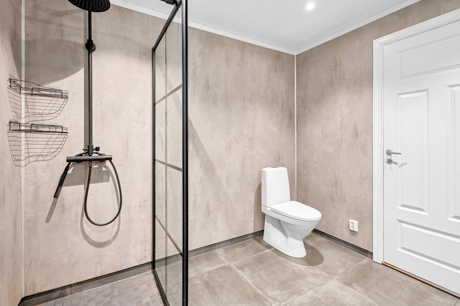 Badet er utstyrt med baderomsinnredning med helstøpt servantplate, klosett og dusjhjørne med innfellbare glassvegger. Galleribilde