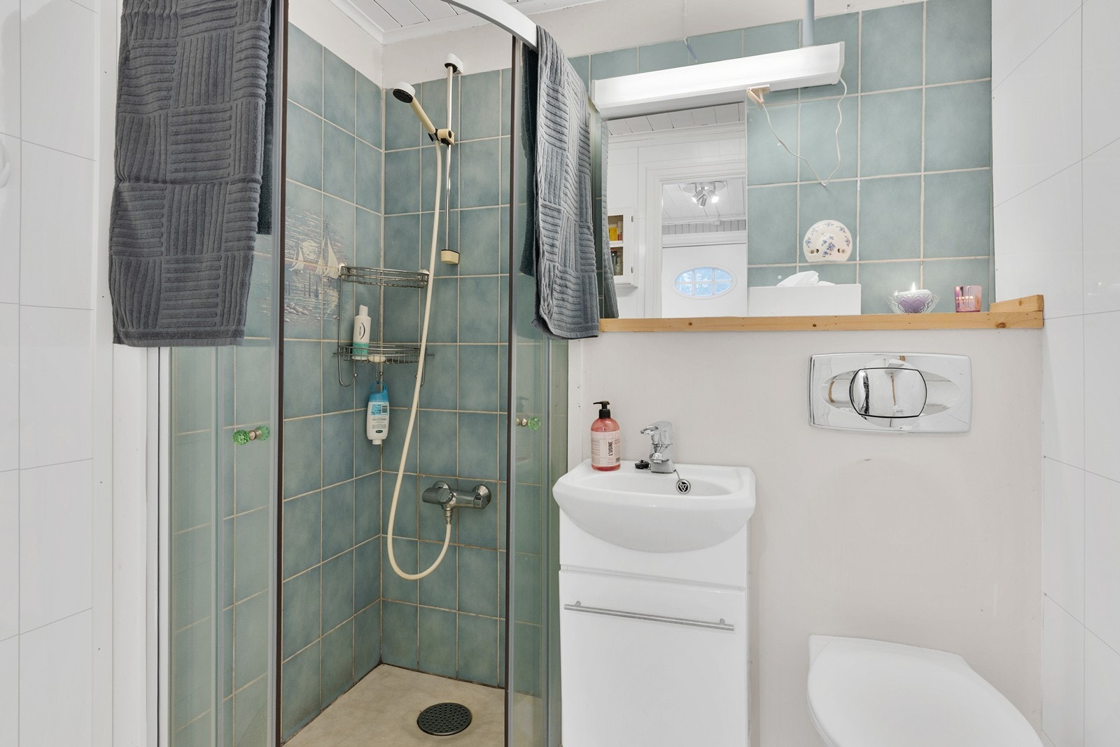 Praktisk bad med gulvbelegg, baderomsplater på vegger og panel i tak. Badet er av eldre dato. Galleribilde