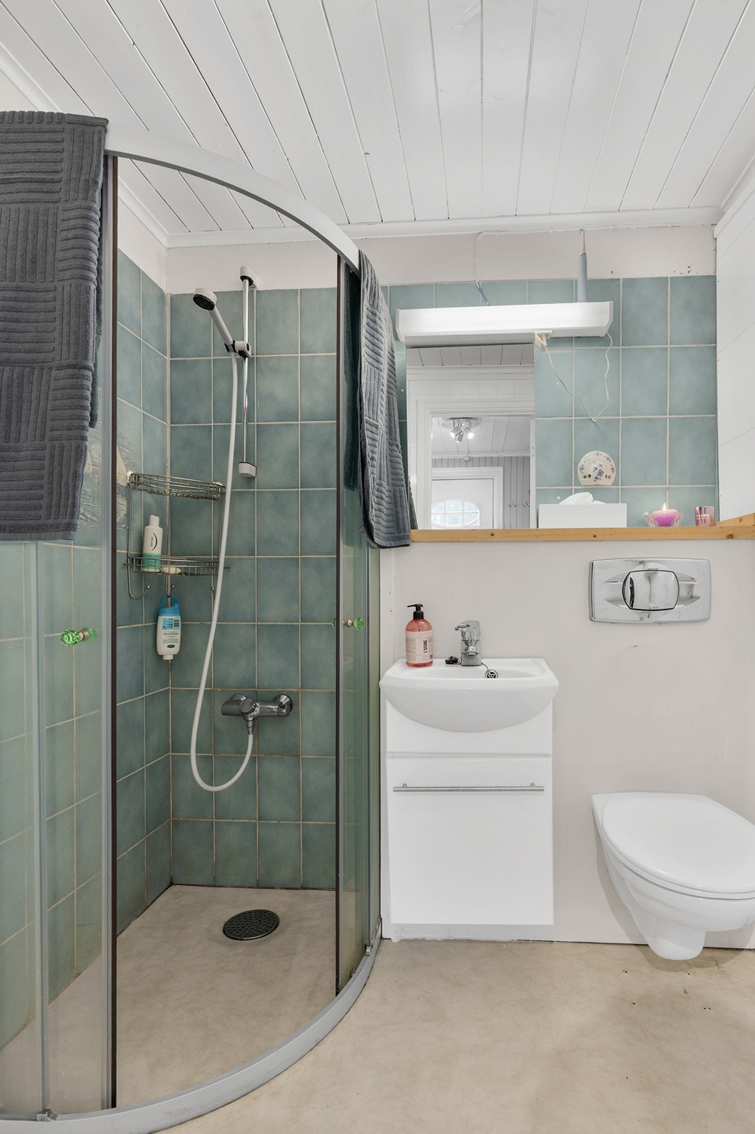 Badet er innredet med servant med tilhørende innredning, vegghengt toalett og dusjhjørne. Galleribilde