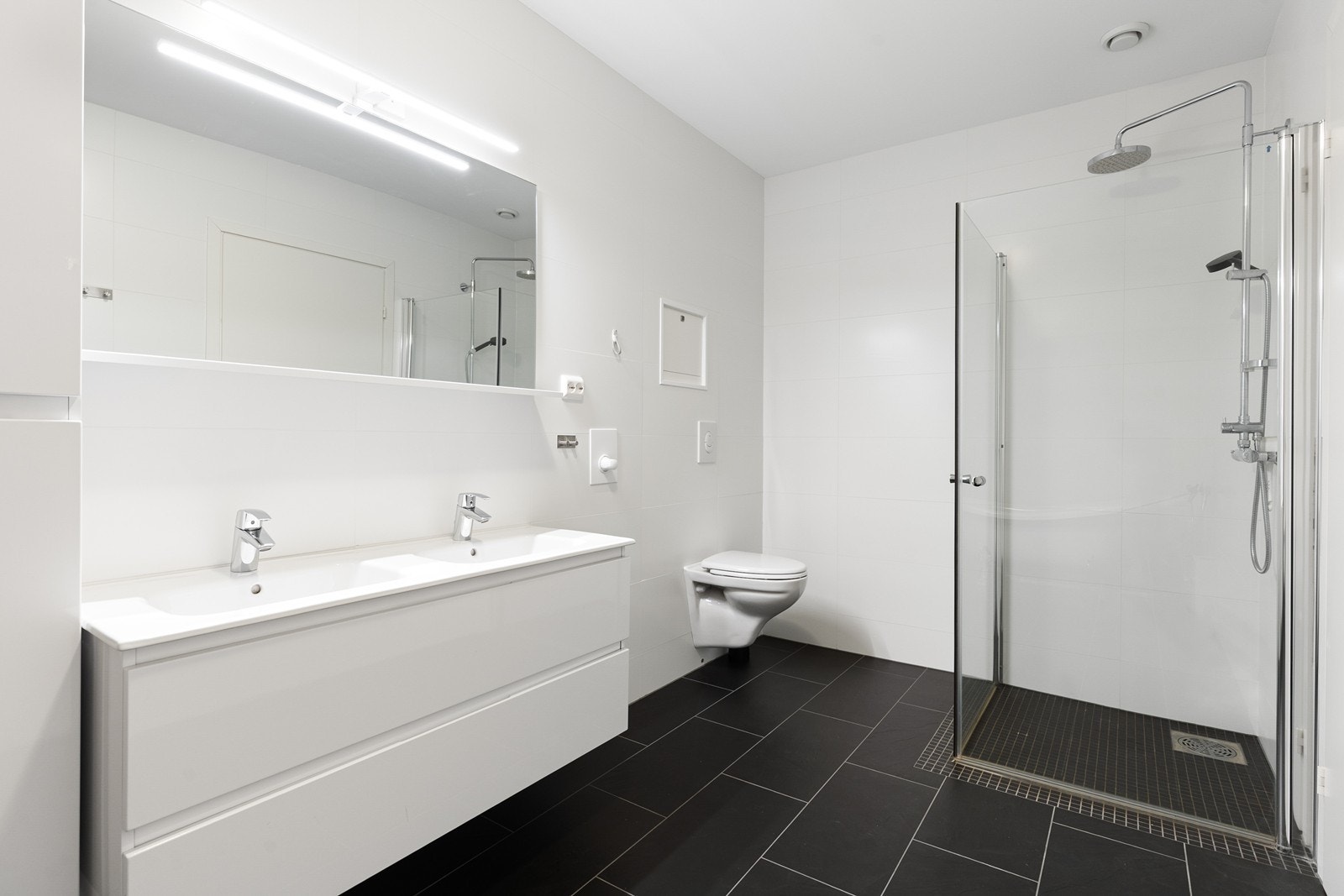 Stort bad i 2. etasje med skuffinnredning, høyskap, speil, wc, dusjhjørne og badekar Galleribilde