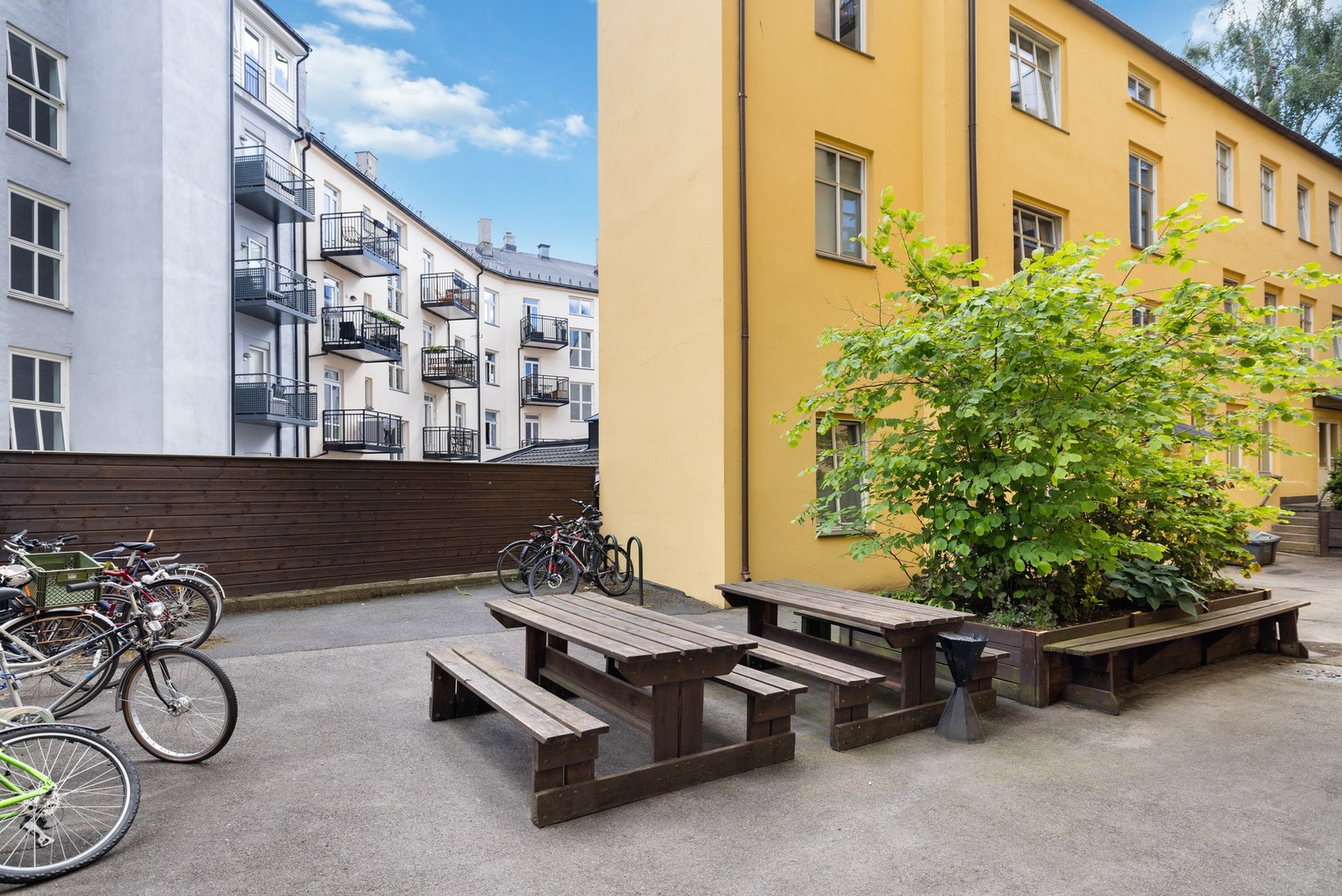 Indre gårdsrom er pent opparbeidet med sittebenker, beplantning, asfalterte veier og sykkelparkering. Galleribilde