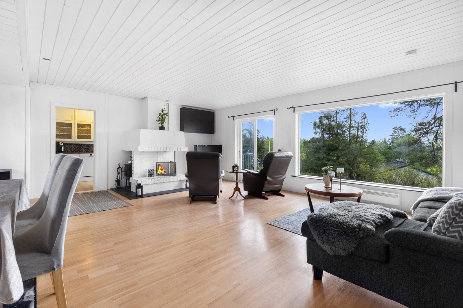 Stuen har god plass til sofamøblement og spisebord, og det er koselig å sette et par godstoler foran peisen. Galleribilde