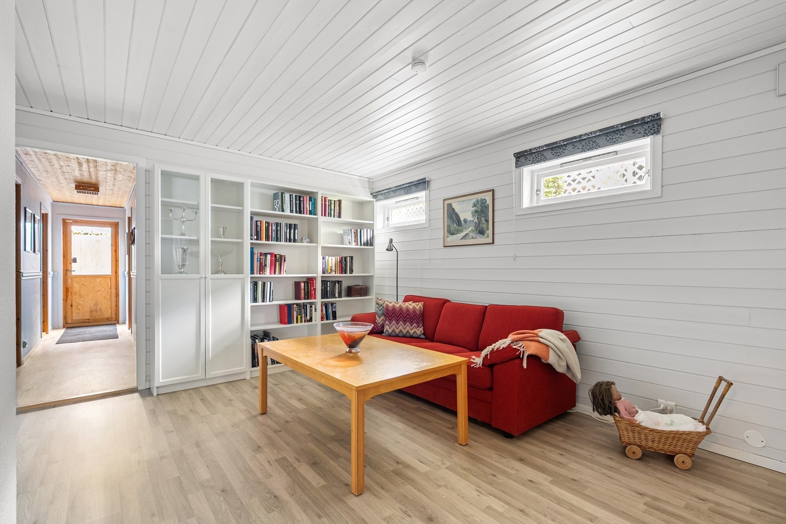 Romslig kjellerstue som kan innredes med flere sittegrupper og tv-seksjon. Bi-inngang til underetasje i enden av gang. Galleribilde
