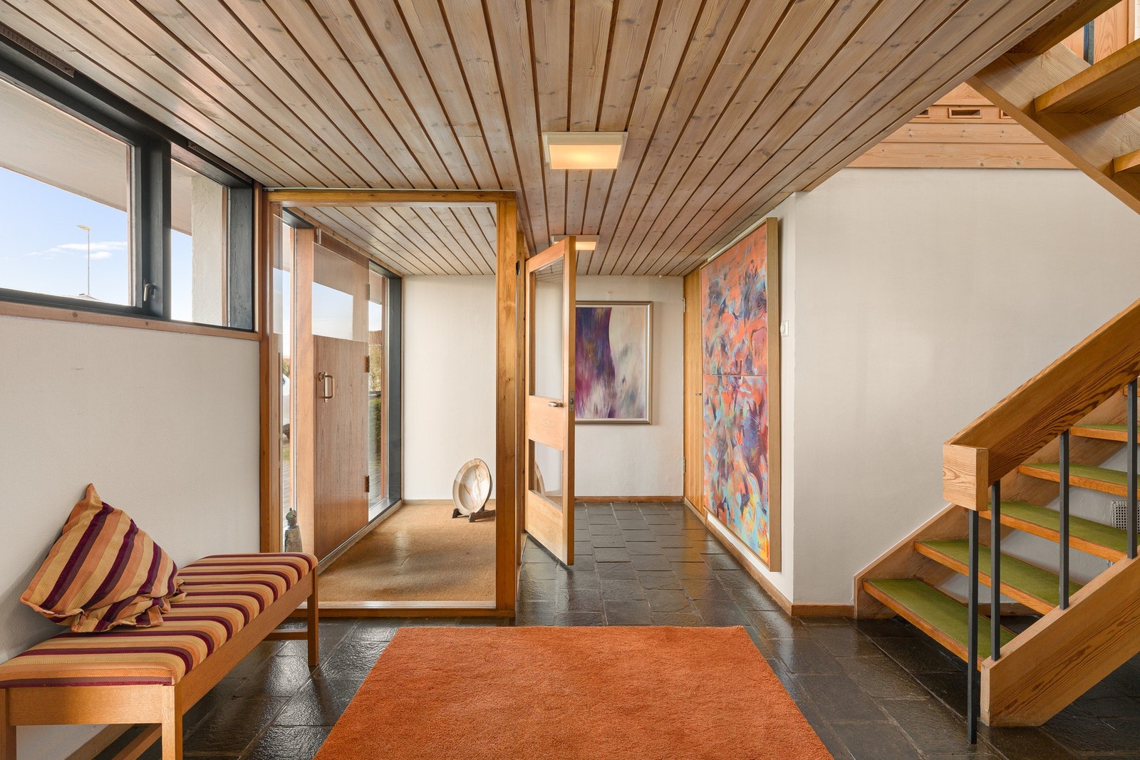 Vindfanget er lyst og luftig med vindu fra gulv til tak mot en romslig hall. I vindfanget er det benyttet slitesterk kokosmatte, mens gulvet i hallen er kledd med skiferfliser. Galleribilde