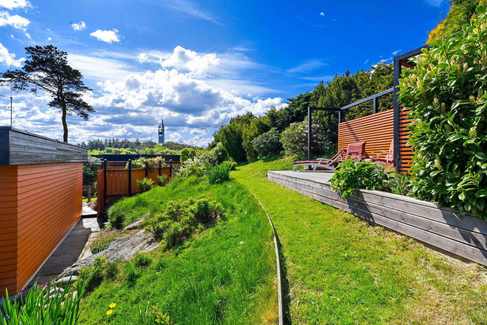 Videre er det en terrasse på ca. 12 kvm i toppen av hagen, oppført med levegg i bakkant Galleribilde