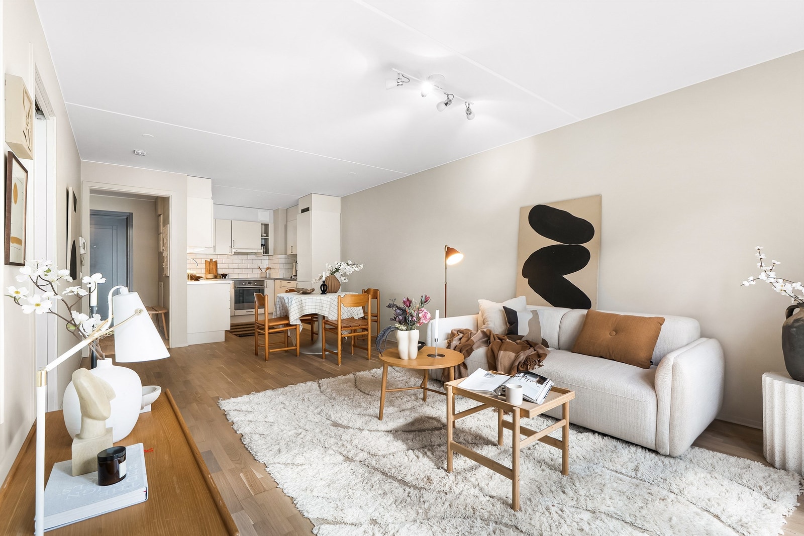 Leiligheten har en lys og trivelig stue med sosial planløsning med åpen kjøkkenløsning. Foto: Oh Shots. Galleribilde