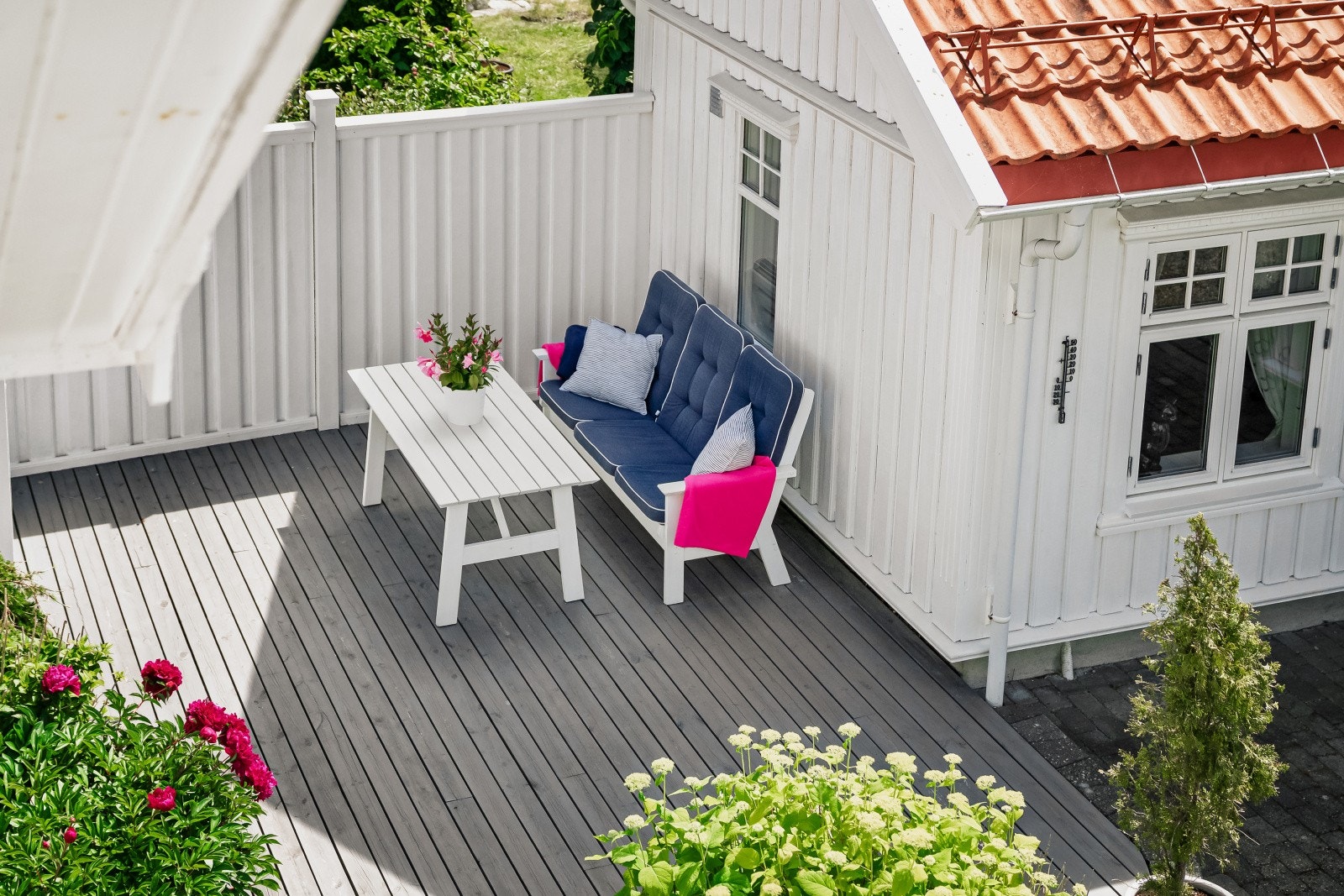 Ved boligens inngangsparti er det opparbeidet et sjenerøst uteområde med skifér og belegningsstein, samt en lun terrasseplatting bak boden. Galleribilde