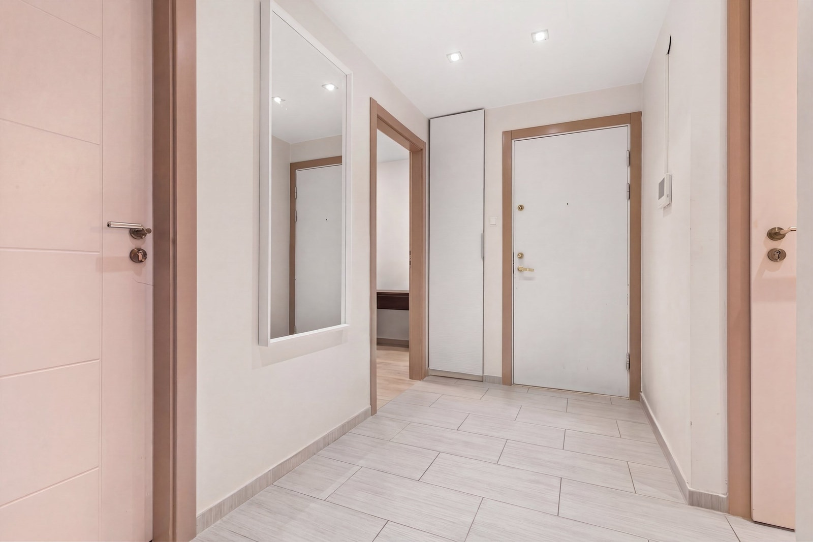 Velkommen inn! Innbydende entré med flislagt gulv, downlights i himling og plass til garderobeløsning. Døren er lyd- og brannklassifisert. (Stylet med AI) Galleribilde