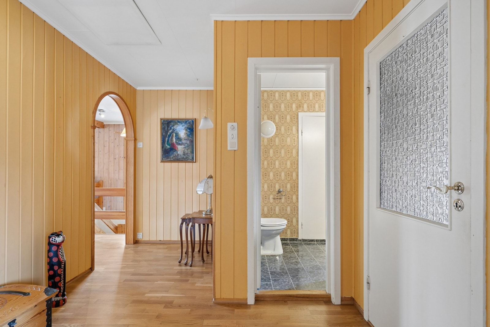 Innvendige overflater i gangen, stue og kjøkken består av malte trepaneler og plater, samt parkett på gulvet. Galleribilde