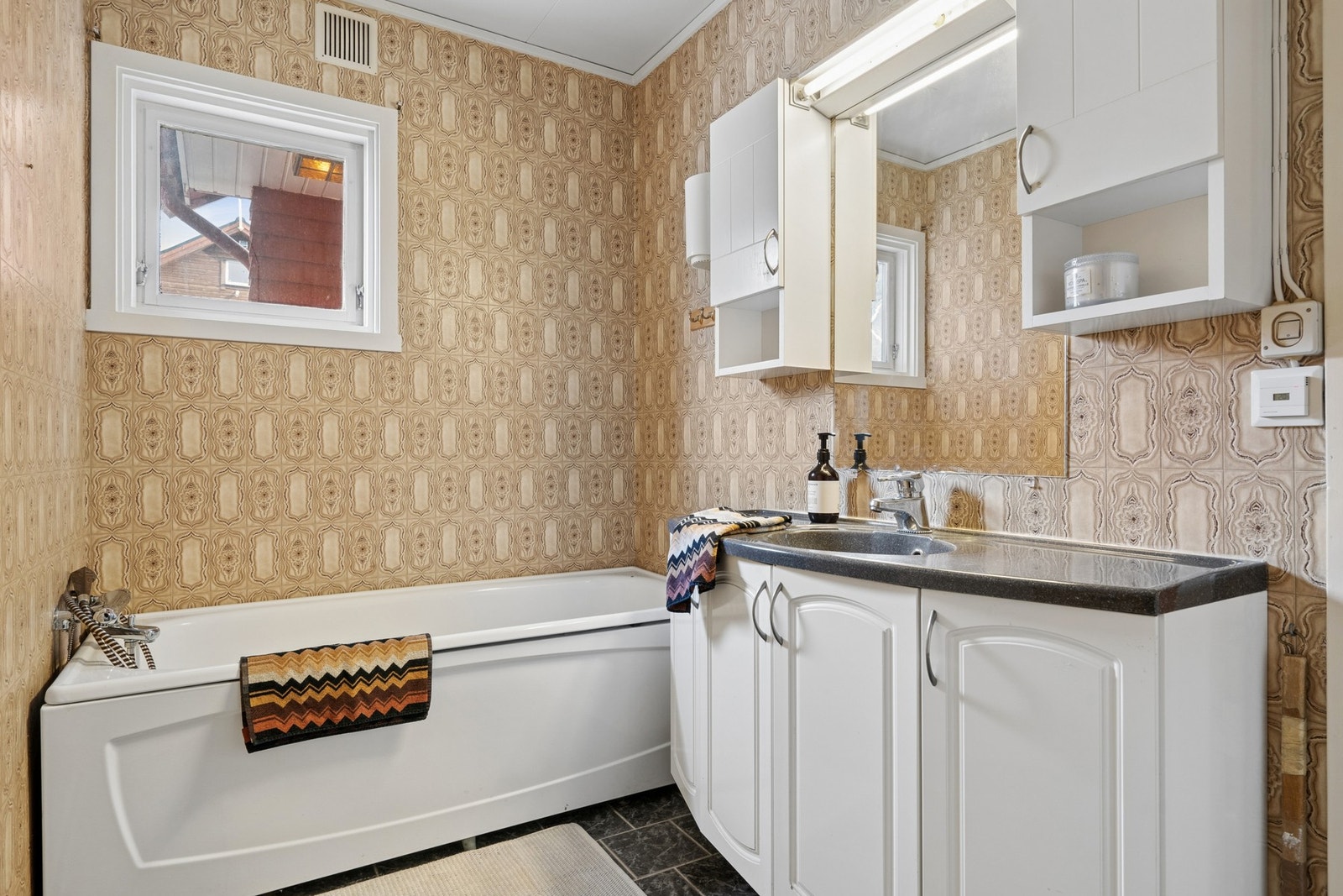 Innredet med badekar, toalett, vask og lys baderomsinnredning. Galleribilde