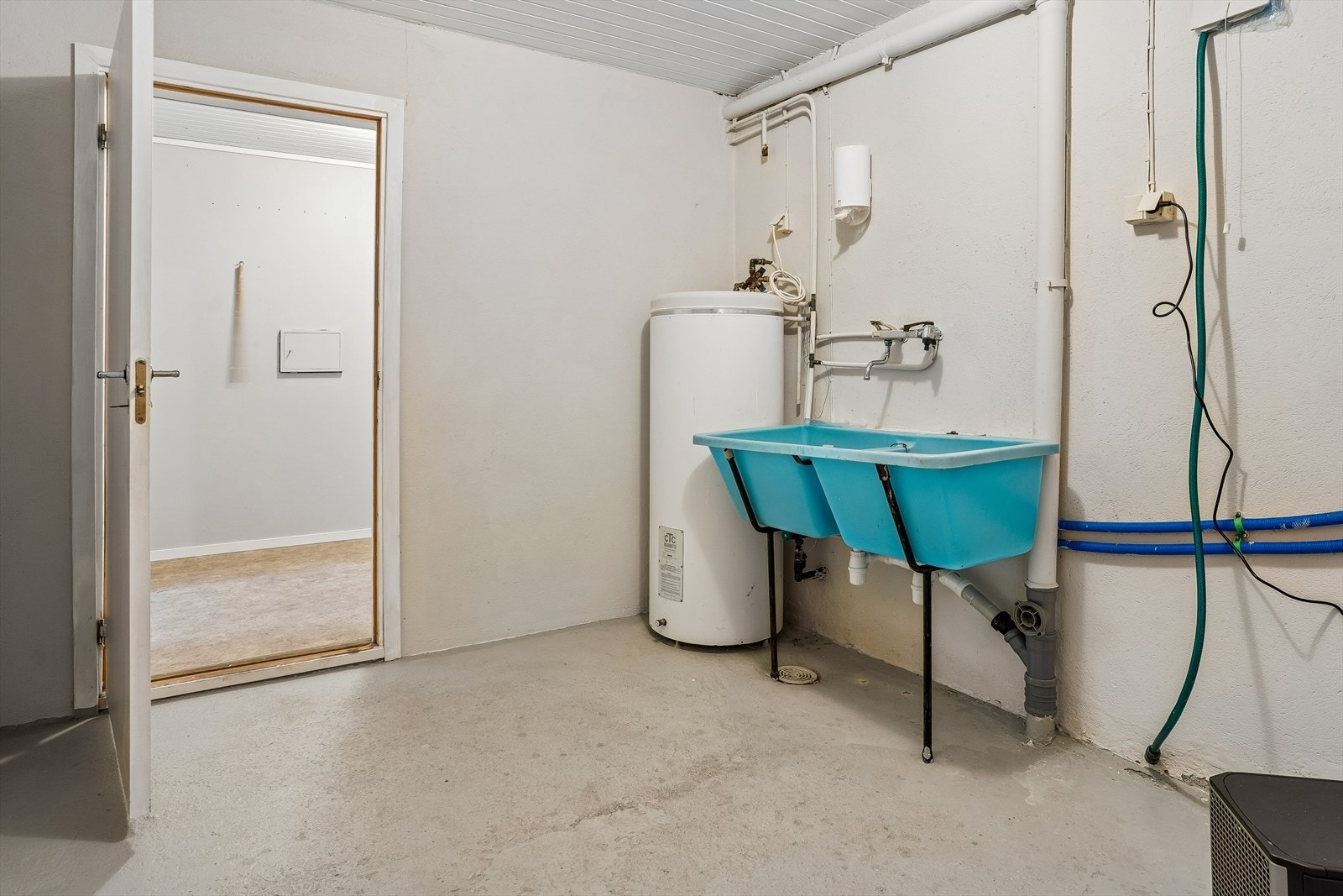 Vaskerom i underetasjen med støypt plate på golvet. Her er også vassfordelingsskapet for rør-i-rør-systemet plassert, samme ved varmtvasstank. Galleribilde