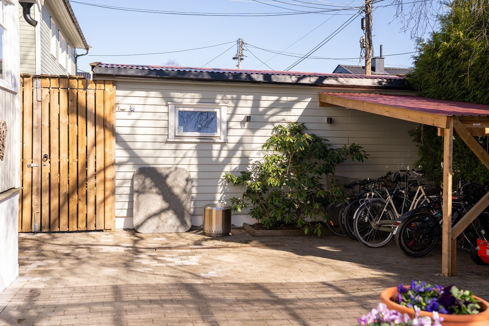 Boligen har skjermet inngangsparti, delt med overetasjen. Her er det etablert felles sykkelparkering. Galleribilde