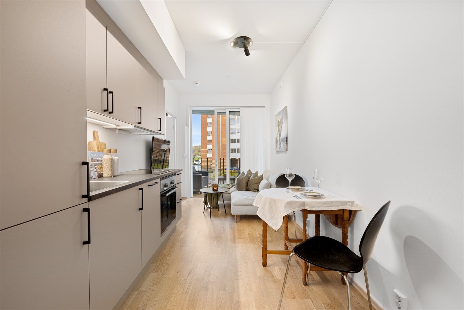 Den smarte planløsningen i leiligheten legger til rette for en egen seksjon for spisebord, som er med på å separere stuearealet fra kjøkkenet. Galleribilde