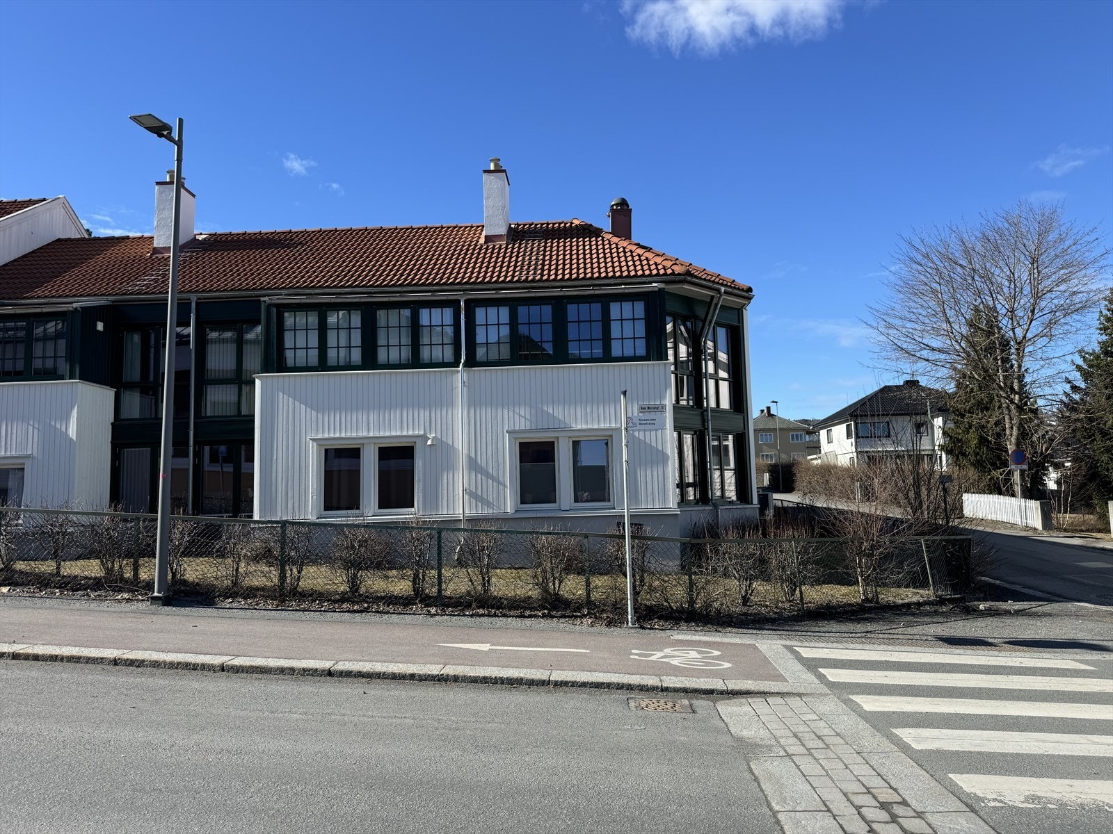 Leilighetens vinduer er innrammet av den hvite panelen og går videre rundt hjørnet til høyre i bildet Galleribilde