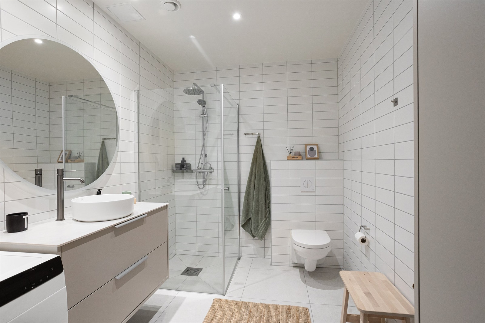 Badet er pent flislagt på gulv og vegger. Varme i gulvet sørger for en behagelig start på dagen. Galleribilde