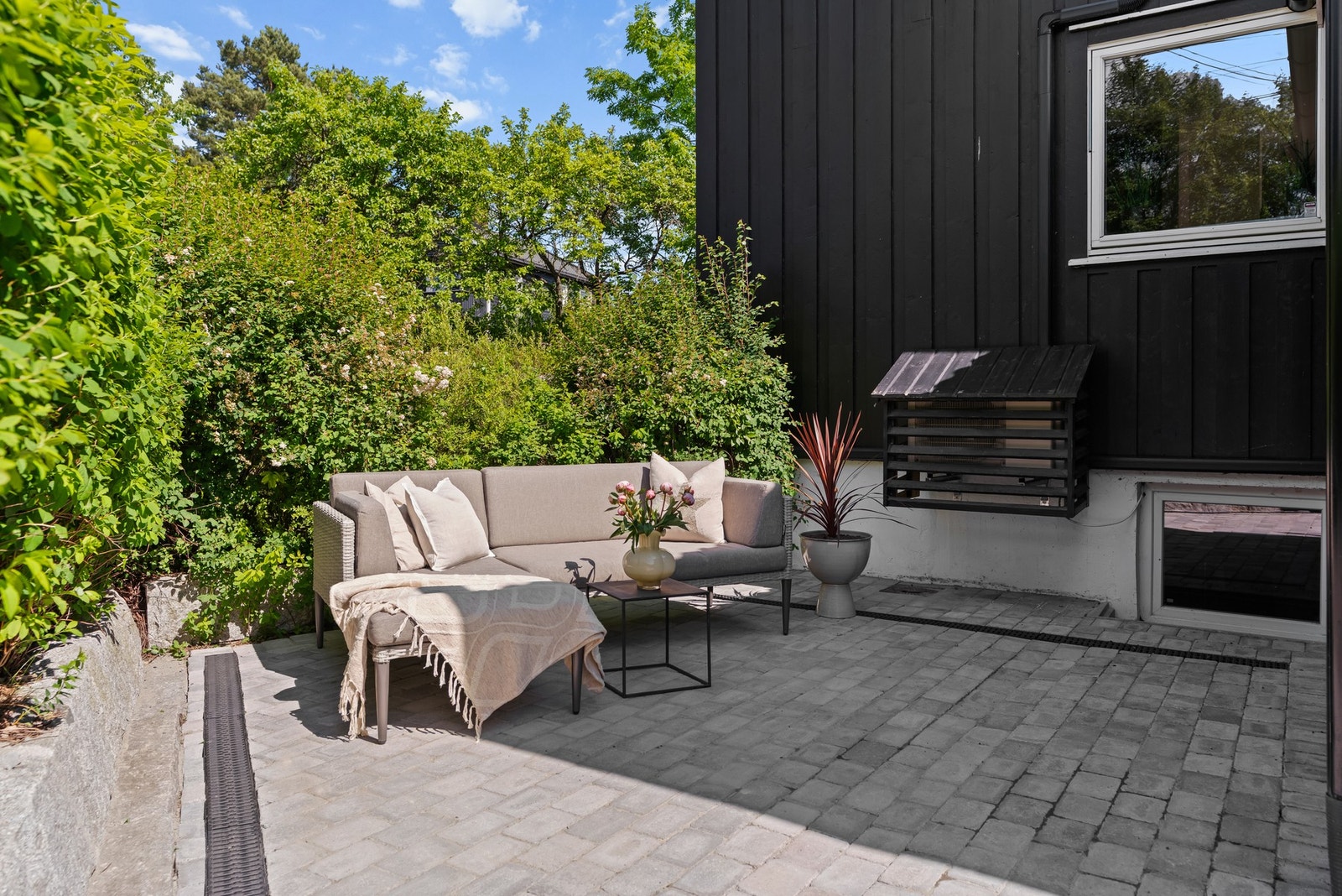 På fremsiden av boligen er det også en fin uteplass med plass for møblement og grill Galleribilde