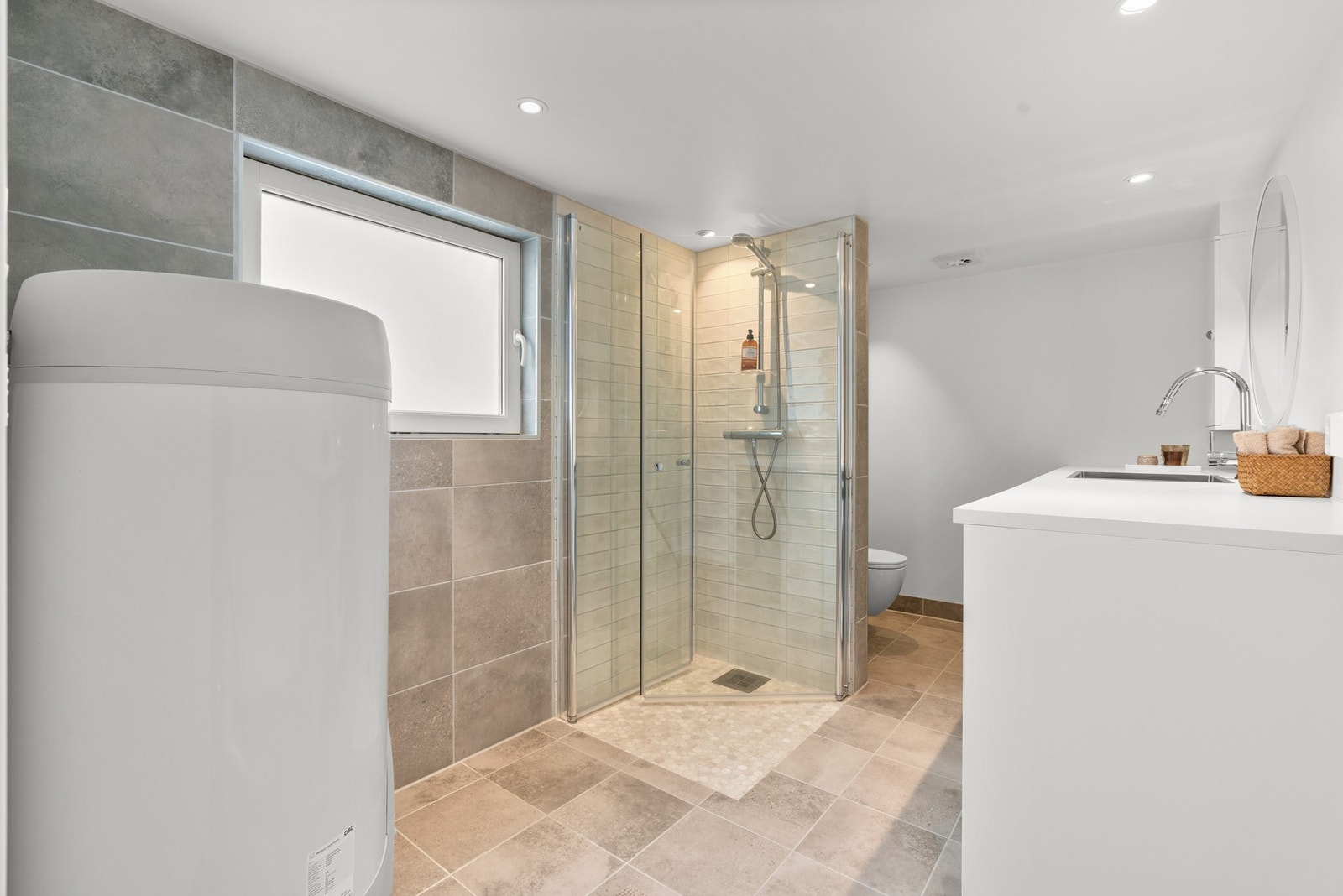 Romslig bad/vaskerom med varmekabler og opplegg for både vaskemaskin og tørketrommel Galleribilde