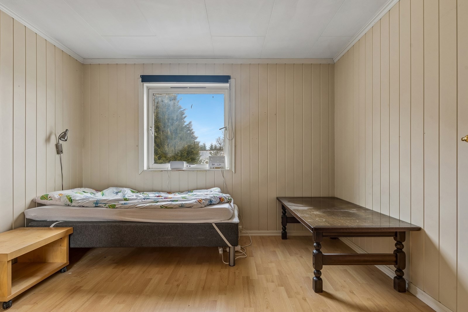 Rommet har panel på veggene og laminat på gulvet. Galleribilde