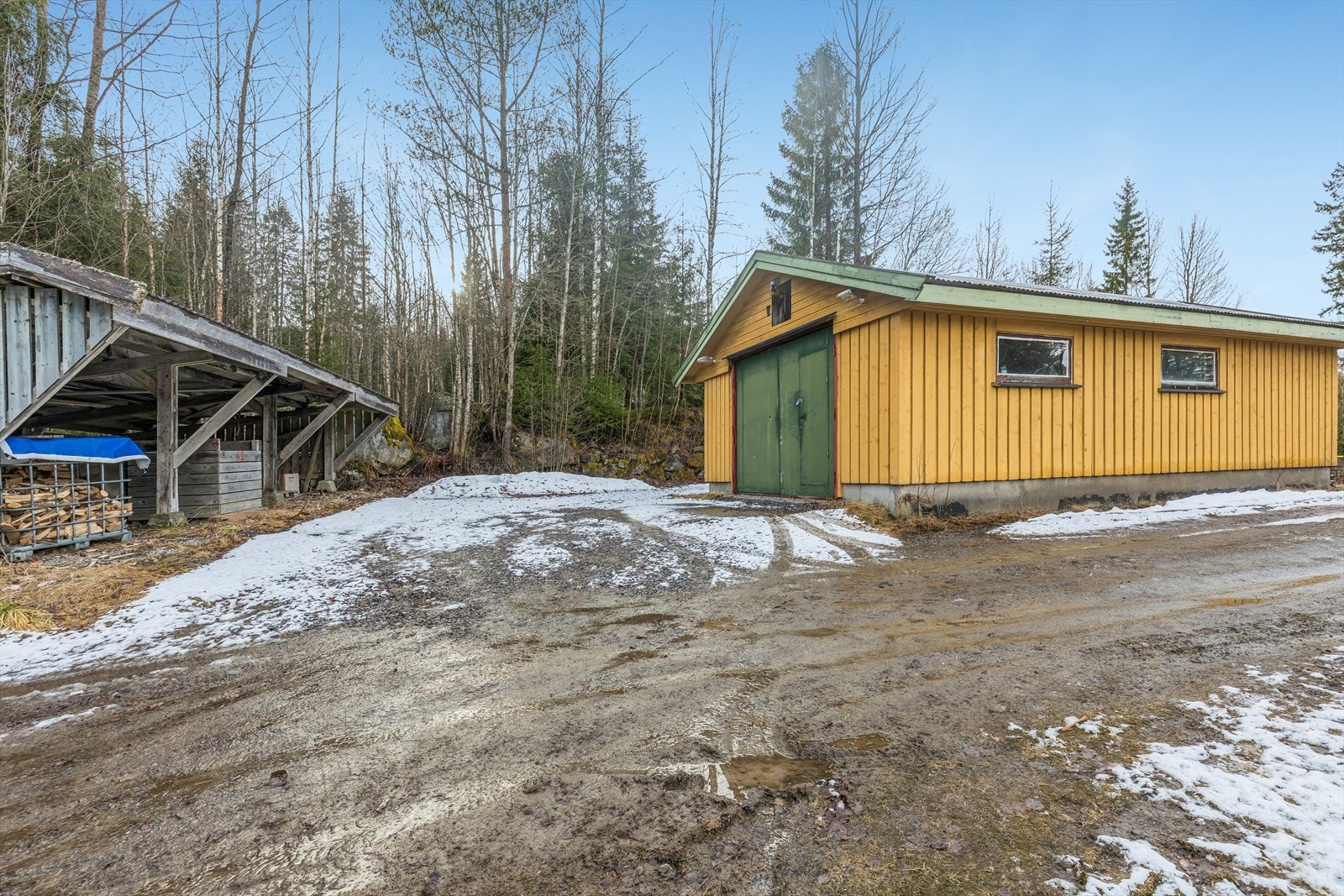 Eiendommen inkluderer en isolert garasje/verksted på 46 m² (2007) og en carport med plass til tre biler. Galleribilde