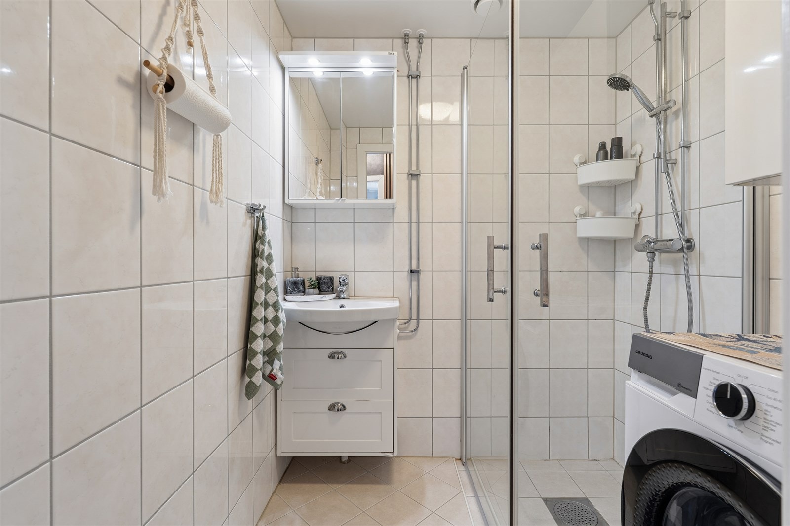 Badet er utstyrt med servant med innredning, speilskap, dusjhjørne og røropplegg til vaskemaskin. Badet er rehabilitert i regi av borettslaget. Galleribilde