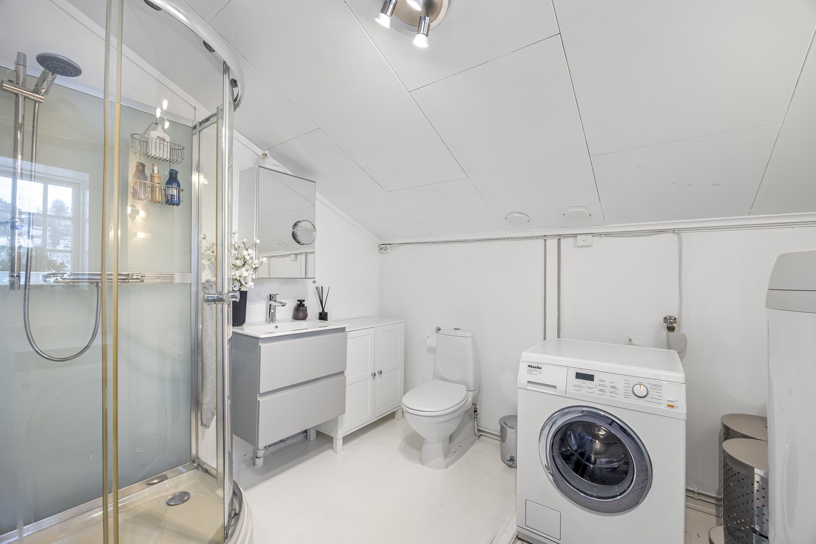 Badet i hyblen er utstyrt med dusjkabinett, toalett og servantinnredning. Det er varmekabler i deler av gulvet. Galleribilde
