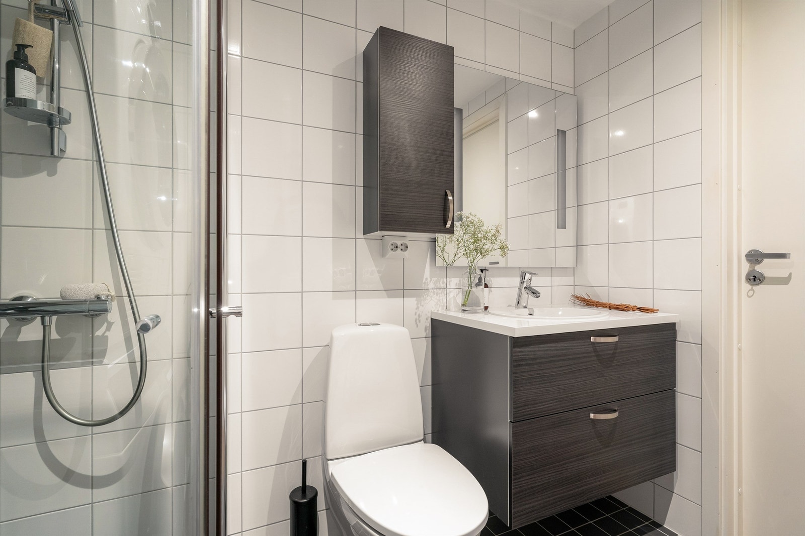 Baderomsinnredning fra HTH, vegghengt klosett for enklere renhold og praktiske dusjvegger i glass. Galleribilde