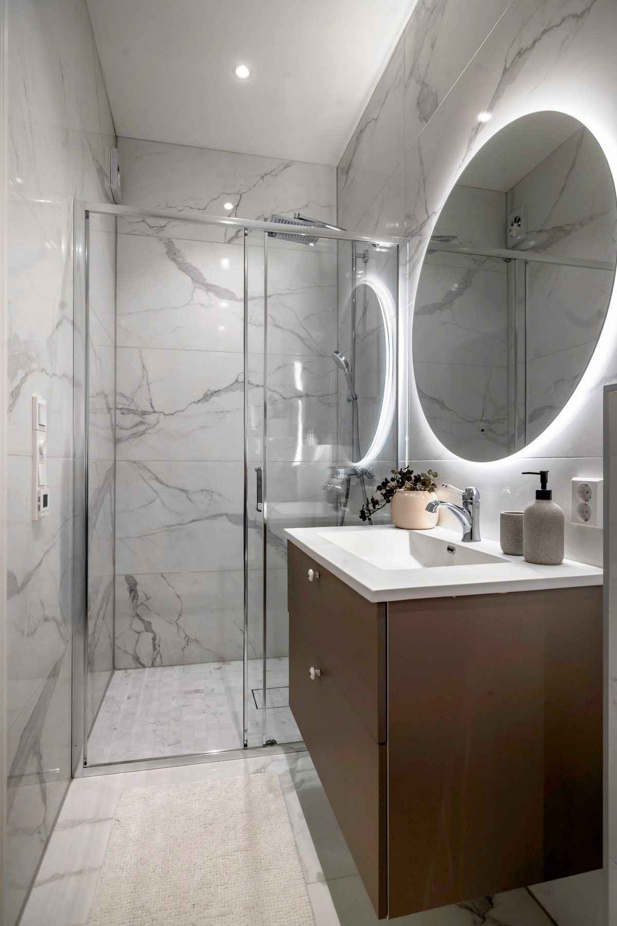 Over servanten er det speil med integrert belysning. Badet er videre utstyrt med downlights og varmekabler i gulv. Galleribilde