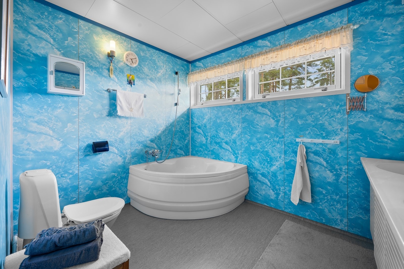 Badet i 1. etasje innredet med heldekkende dobbeltservant, speil med belysning, badekar og gulvstående toalett Galleribilde
