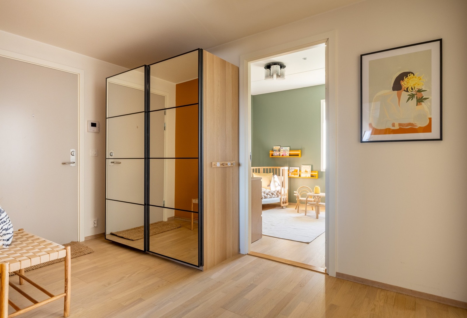 Blir ønsket velkommen inn i en stor gang, innredet med garderobeløsning. Galleribilde