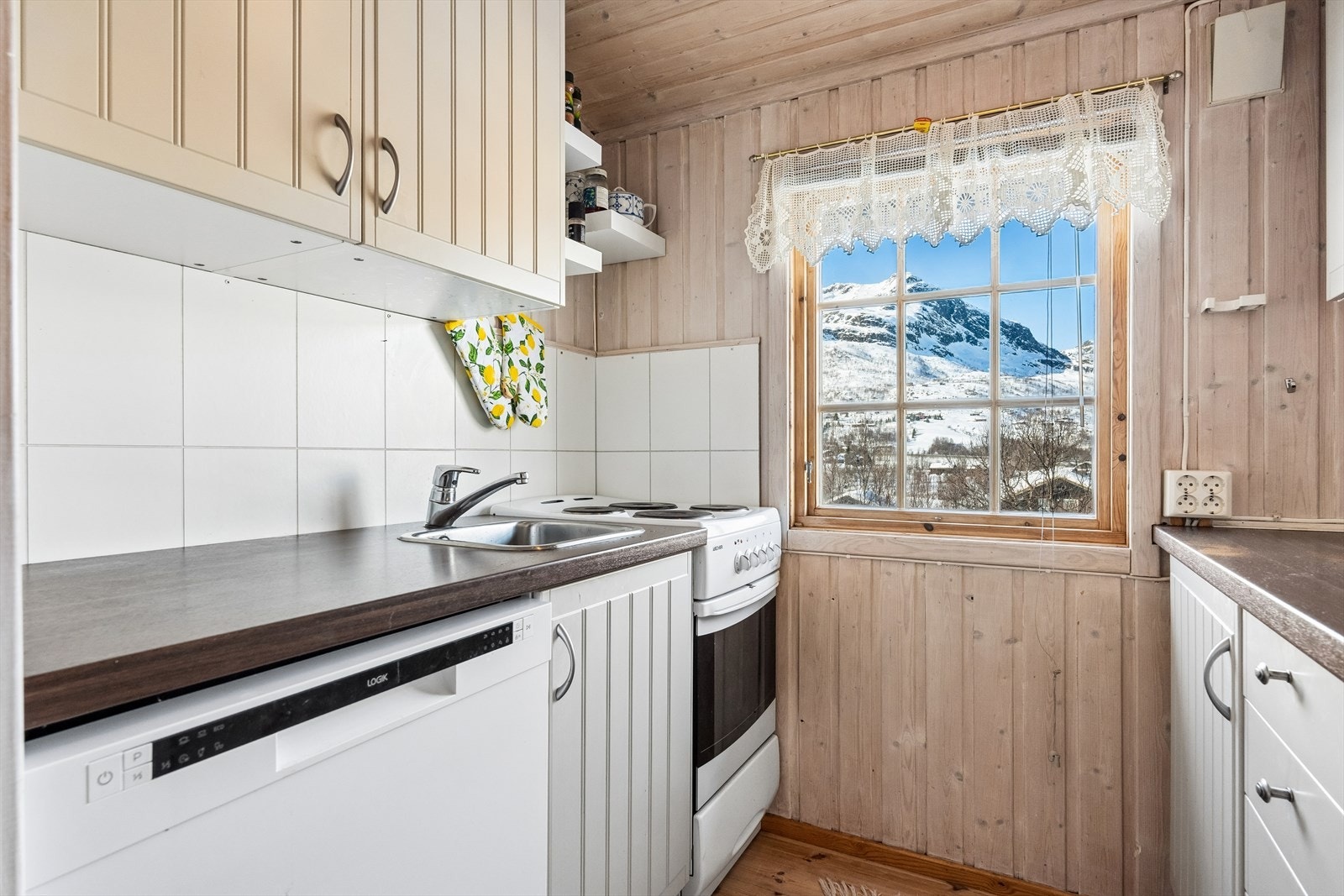På kjøkkenet er det lys innredning fra Ikea med skufferekker, under- og overskap. Kjøkkeninnredningen har profilerte fronter og benkeplate av laminat med nedfelt kjøkkenvask i stål. Galleribilde