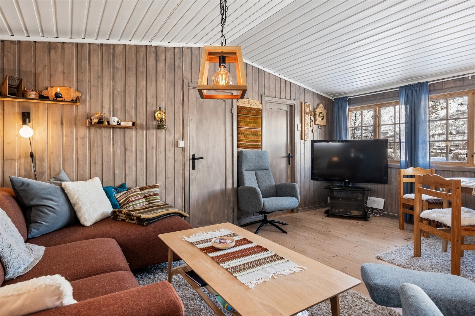 Inne i hytta er det en lys og luftig stue med mønet himling. Galleribilde