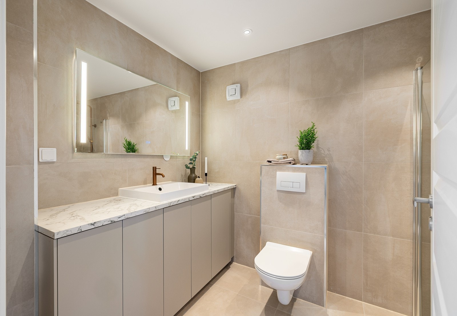 Delikat bad med dusjhjørne og moderne armatur i varme toner. Galleribilde