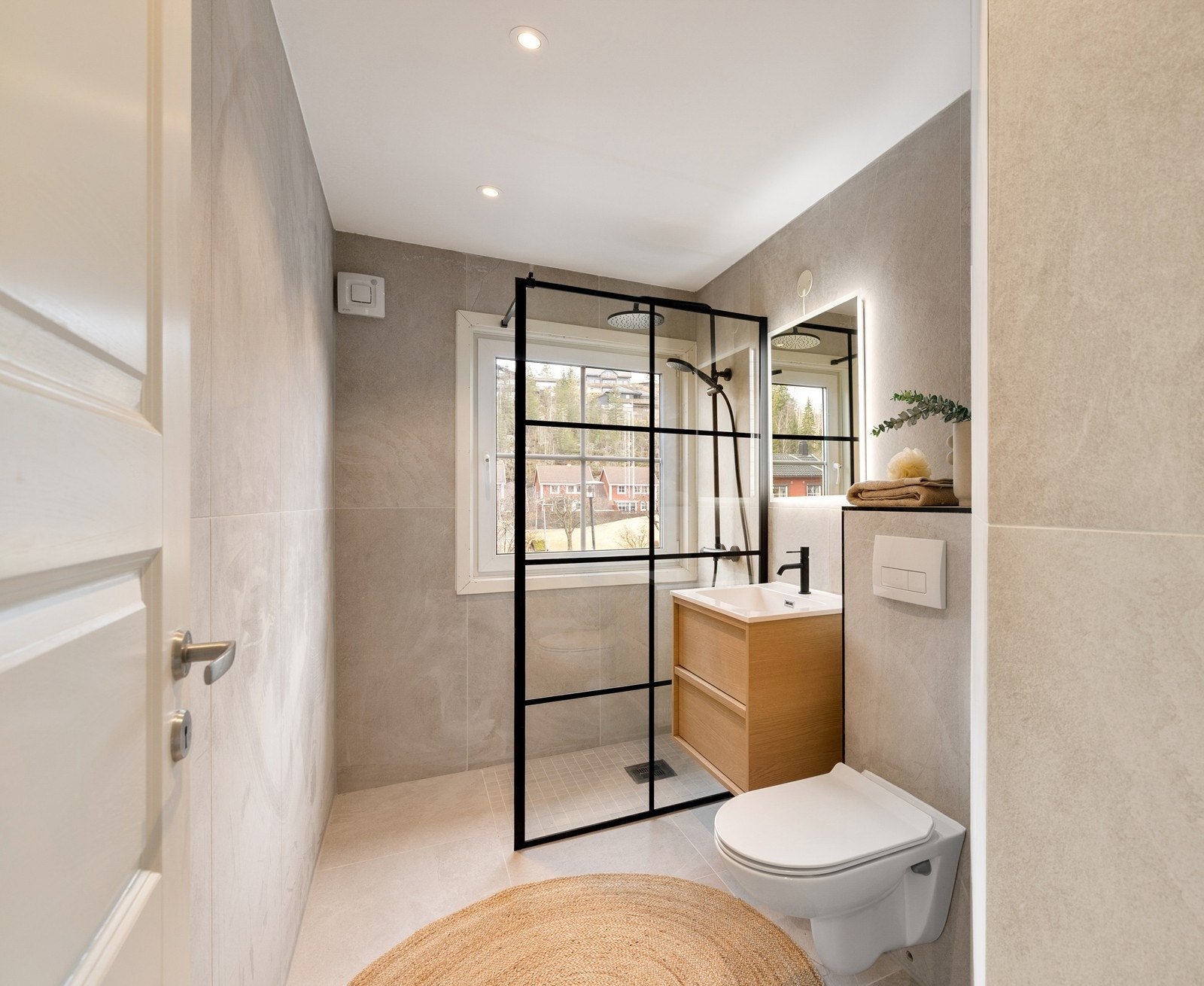 Lyst og delikat bad med vegghengt toalett og dusjløsning. Galleribilde