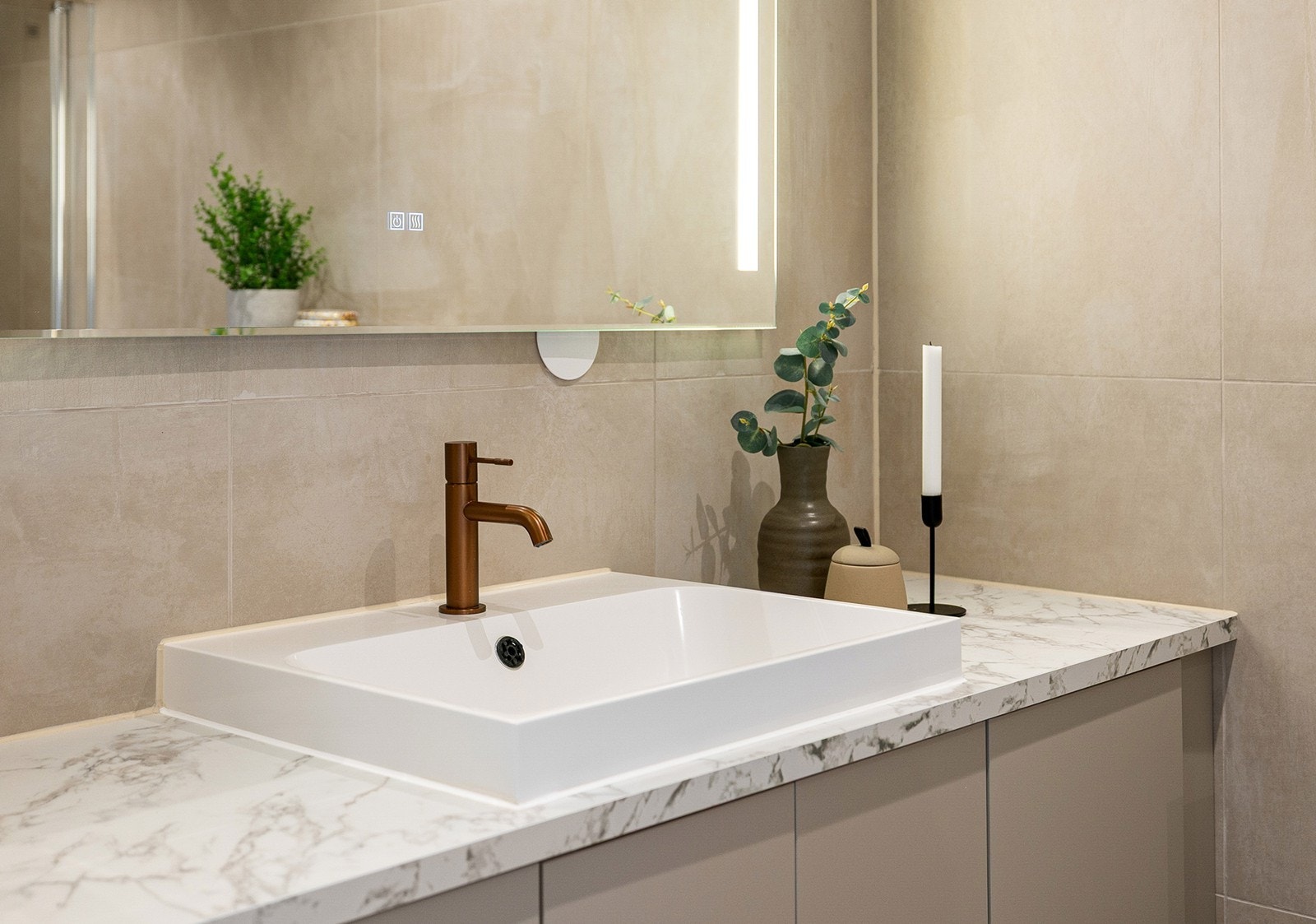 Stilrent servantskap med marmorert benkeplate og integrert belysning. Galleribilde