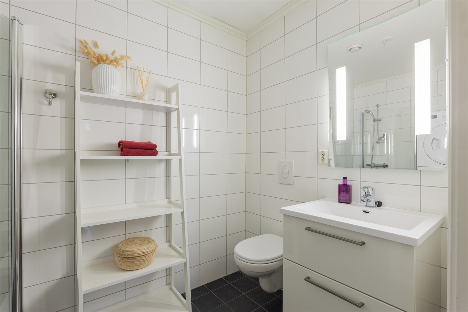 Badet i underetasjen er et kombinert bad/vaskerom - praktisk, med et stilrent og tidløst uttrykk. Galleribilde
