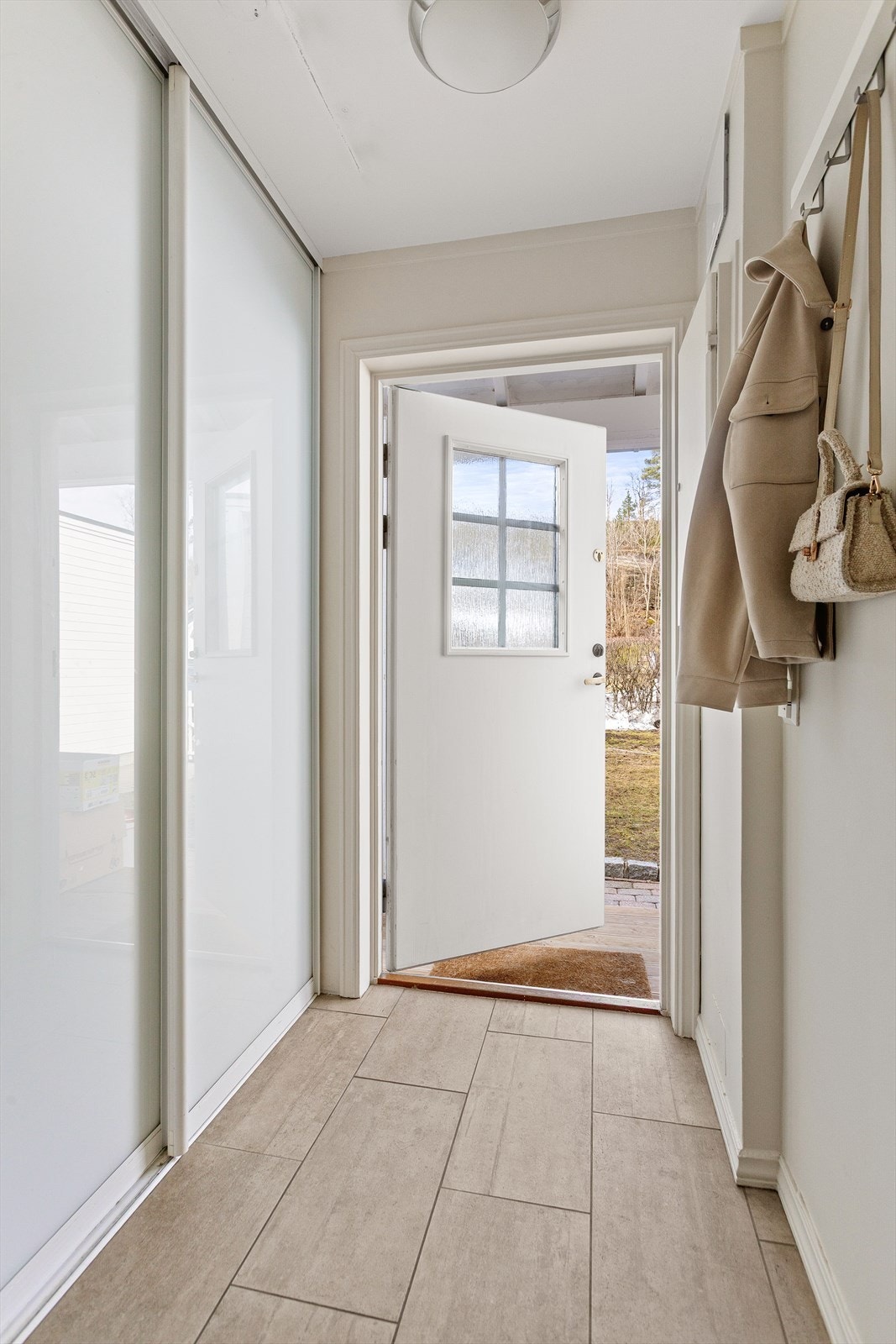 Flislagt entré med gulvvarme. Skyvedørsgarderobe med god plass til oppbevaring Galleribilde