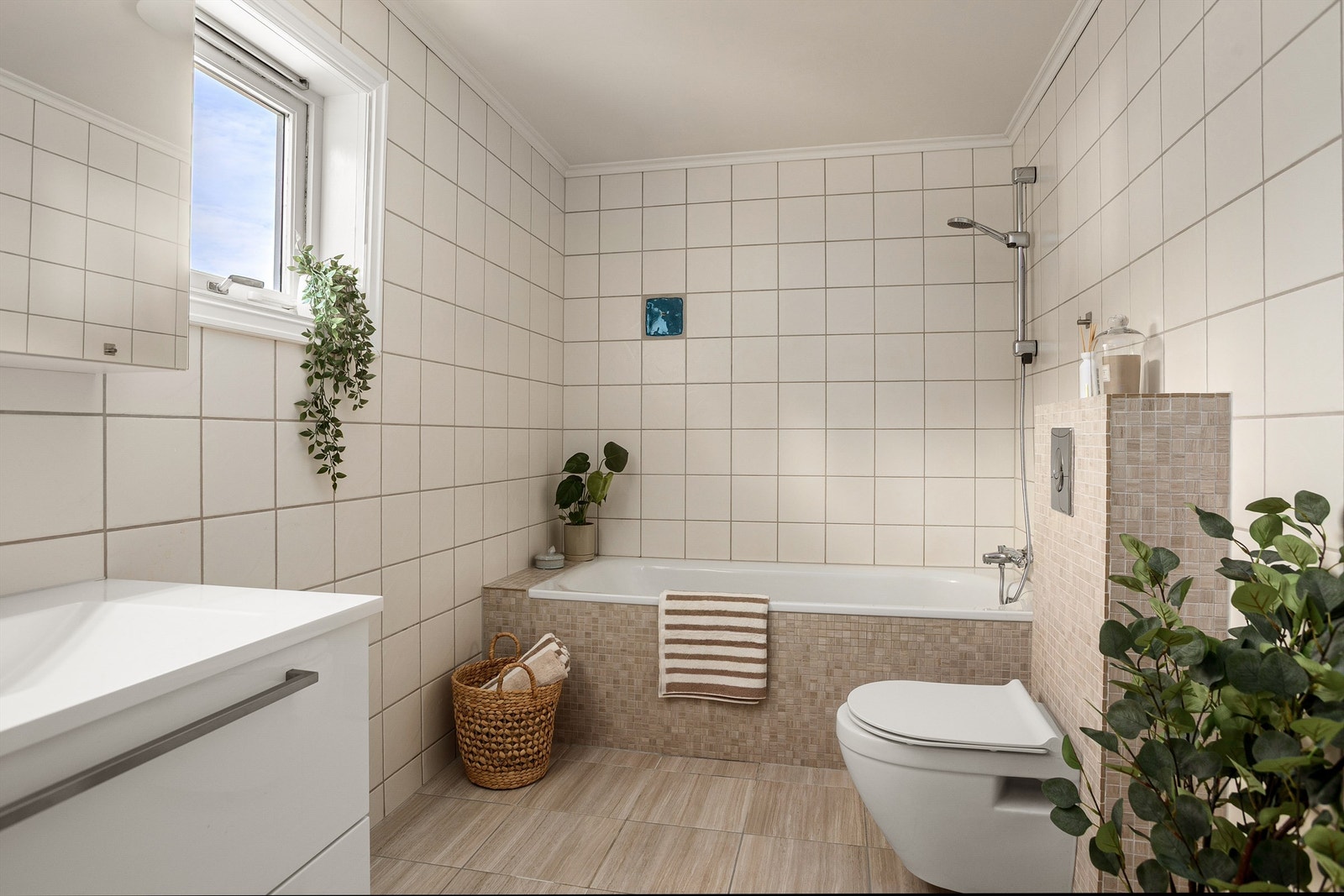 Romslig flislagt bad med gulvvarme. Badet ble i 2018 oppgradet med flis på flis på gulv, samt mosaikkfliser rundt sisterne og badekar Galleribilde
