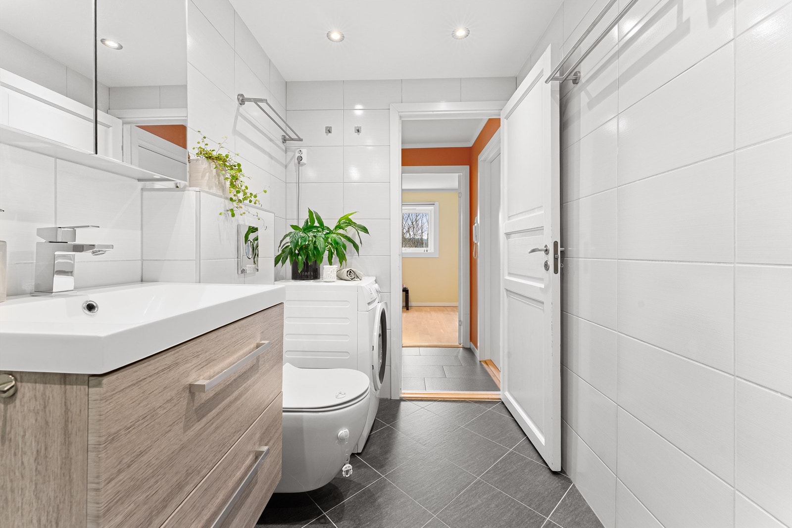 Badet er utstyrt med vegghengt toalett, dusjhjørne med regnfallsdusj og opplegg for vaskemaskin. Galleribilde