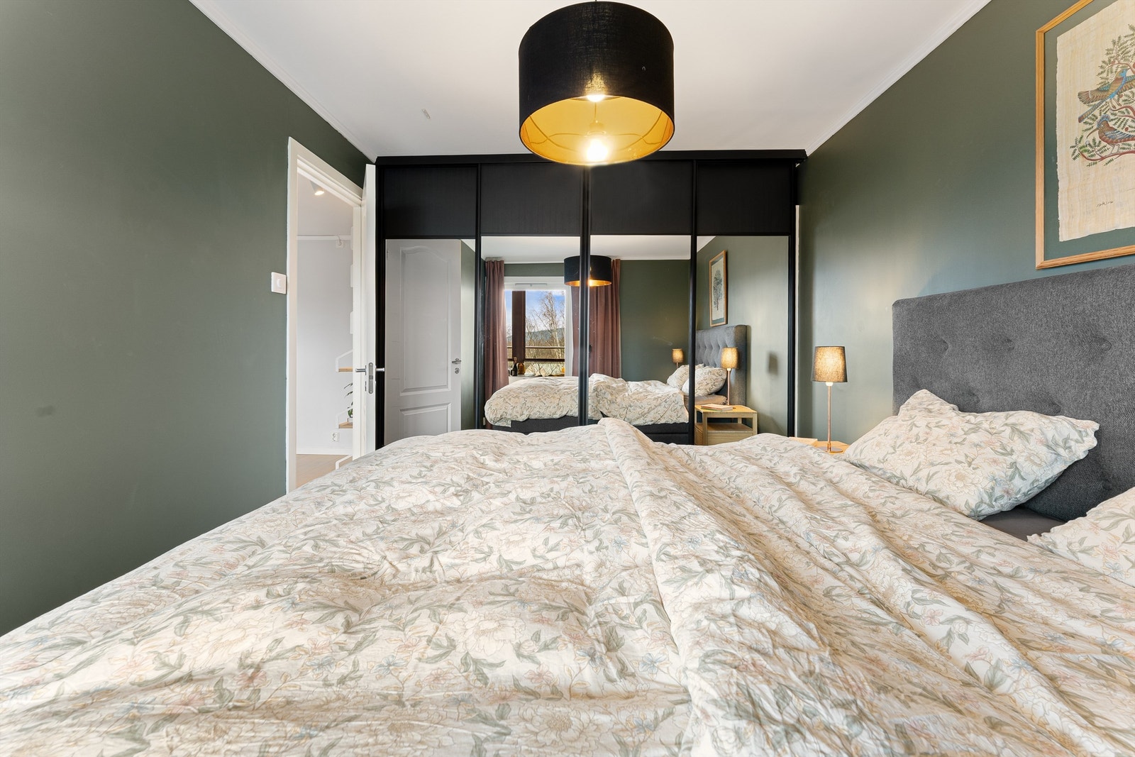 En romslig skyvedørsgarderobe med speilfronter gir rikelig med oppbevaringsplass. Galleribilde
