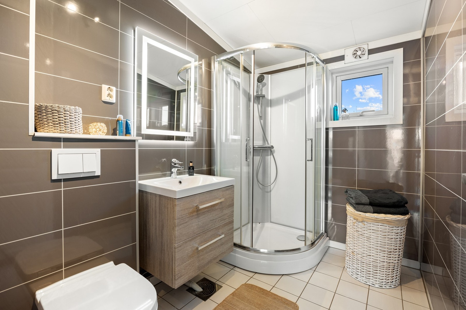 Badet ligger i boligens 2. etasje og ble pusset opp i regi av borettslaget i 2017. Badet fremstår moderne med flisimiterte baderomsplater på veggene og flislagt gulv med gulvvarme. Galleribilde