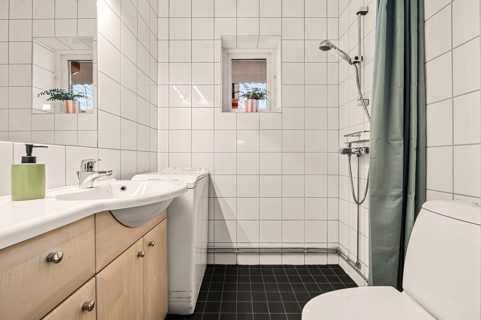 Badet har flislagte overflater, gulvvarme og enkel innredning, samt røropplegg for vaskemaskin. Galleribilde