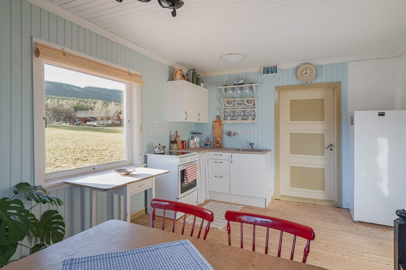 Kjøkkenet har lyse originale tregulv (pusset og behandlet i 2022/23) og panel på veggene malt i en fin lys blåfarge. Galleribilde